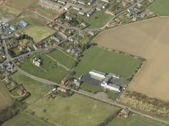 Oblique aerial view centred on the school with the church, burial ground and dovecot adjacent, taken from the SE.