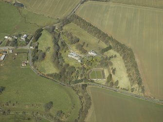 Oblique aerial view centred on the country house and walled garden with the gate-lodge and road bridge adjacent, taken from the S.