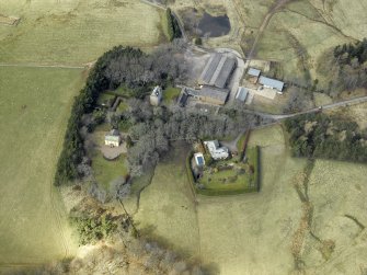 Oblique aerial view centred on the remains of the tower-house and the farmsteading, stable and farmhouse, taken from the SE.
