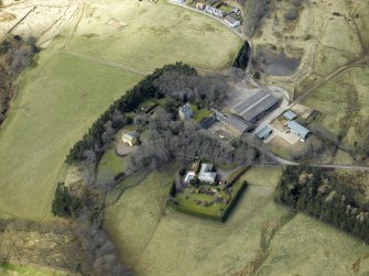 Oblique aerial view centred on the remains of the tower-house and the farmsteading, stable and farmhouse, taken from the ESE.