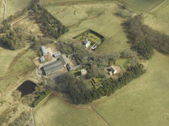 Oblique aerial view centred on the remains of the tower-house and the farmsteading, stable and farmhouse, taken from the WNW.