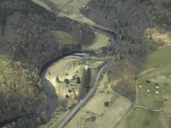 Oblique aerial view centred on the remains of the castle, outbuildings and walled garden with the railway viaduct adjacent, taken from the ENE.