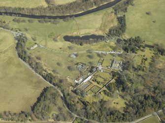 Oblique aerial view centred on the country house, gardens, walled garden and stables with the dovecot adjacent, taken from the SW.