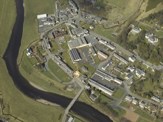 Oblique aerial view centred on the woollen mill with the road bridge and convent  adjacent, taken from the ESE.