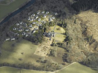Oblique aerial view centred on the country house and housing estate, taken from the WSW.