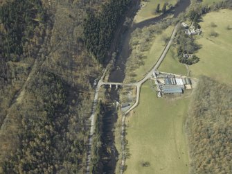 Oblique aerial view centred on the road bridge with the farmhouse, farmsteading and sawmill adjacent, taken from the E.