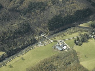 Oblique aerial view centred on the road bridge with the farmhouse, farmsteading and sawmill adjacent, taken from the NNE.