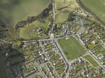 Oblique aerial view of the village centred on the hall with the church and monument adjacent, taken from the ENE.