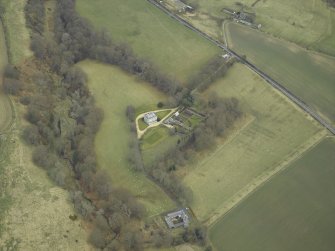 Oblique aerial view centred on the country house with stables, gate-lodge, gate piers and gates adjacent, taken from the WNW.