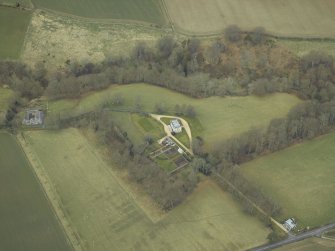 Oblique aerial view centred on the country house with stables, gate-lodge, gate piers and gates adjacent, taken from the S.