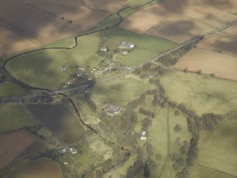 General oblique aerial view centred on the country house and stables with the gate-lodges, walled garden and village adjacent, taken from the SSW.
