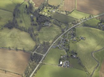 General oblique aerial view centred on the country house and stables with the gate-lodges, walled garden and village adjacent, taken from the NE.