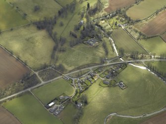 General oblique aerial view centred on the country house and stables with the gate-lodges, walled garden and village adjacent, taken from the N.