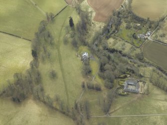 Oblique aerial view centred on the country house and stables with the walled garden adjacent, taken from the NNE.