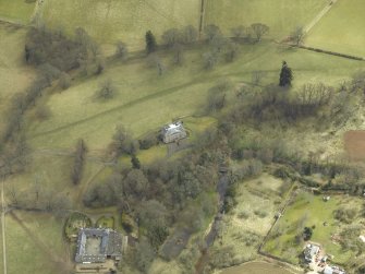 Oblique aerial view centred on the country house and stables with the walled garden adjacent, taken from the NW.
