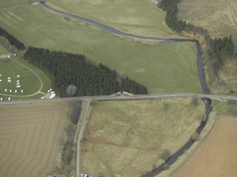Oblique aerial view centred on the gates with the caravan site and road bridge adjacent, taken from the SSE.