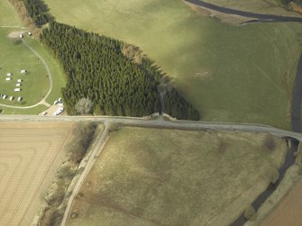 Oblique aerial view centred on the gates with the caravan site and road bridge adjacent, taken from the SE.