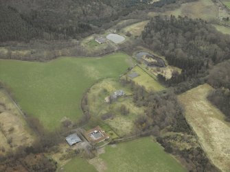 Oblique aerial view centred on the country house, walled garden, farmsteading, stables and dovecot, with the farmstead and corn mill adjacent, taken from the NW.