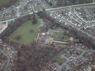 Oblique aerial view centred on the house and walled garden with the gate lodge adjacent, taken from the WSW.