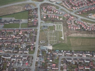 Oblique aerial view centred on the churches, burial-ground and church hall, taken from the S.