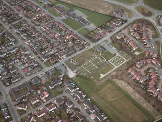 Oblique aerial view centred on the churches, burial-ground and church hall, taken from the SE.