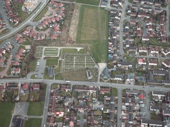 Oblique aerial view centred on the churches, burial-ground and church hall, taken from the W.