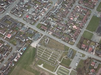 Oblique aerial view centred on the churches, burial-ground and church hall, taken from the NE.