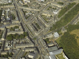 Oblique aerial view centred on the bank and tenements with the school and church adjacent, taken from the WSW.