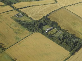 Oblique aerial view centred on the country house, greenhouse, walled garden, granary and farmsteading, taken from the SW.