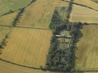 Oblique aerial view centred on the country house, greenhouse, walled garden, granary and farmsteading, taken from the SE.