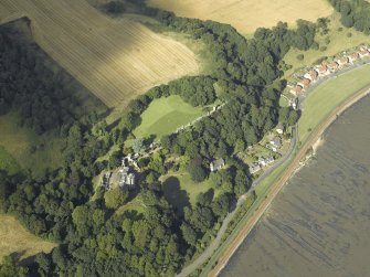 Oblique aerial view centred on the country house, cottage and church, taken from the SW.