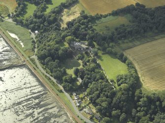 Oblique aerial view centred on the country house, cottage and church, taken from the E.
