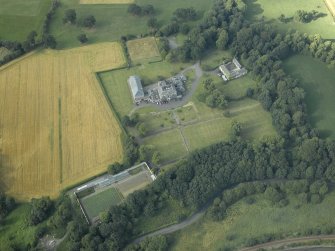 Oblique aerial view centred on the country house, formal garden and stables, taken from the S.