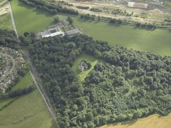 Oblique aerial view centred on the remains of the castle with the railway adjacent, taken from the NE.