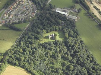 Oblique aerial view centred on the remains of the castle with the railway adjacent, taken from the NNW.