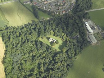 Oblique aerial view centred on the remains of the castle with the railway adjacent, taken from the WNW.