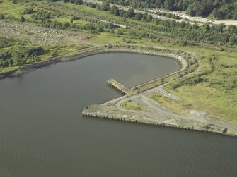 Oblique aerial view of the remains of the shipyard centred on the dock, taken from the SE.