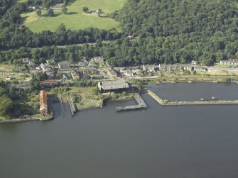 Oblique aerial view of the remains of the harbour and shipyard centred on the buildings and pier, taken from the S.