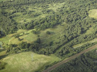 Oblique aerial view centred on the remains of the Roman fort and the course of the Antonine Wall, taken from the SW.