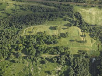 Oblique aerial view centred on the remains of the Roman fort and the course of the Antonine Wall, taken from the NW.