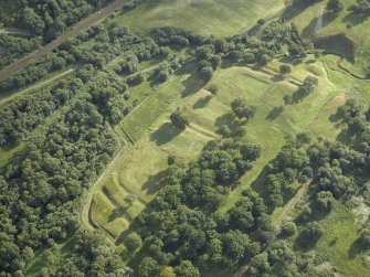 Oblique aerial view centred on the remains of the Roman fort and the course of the Antonine Wall, taken from the NE.