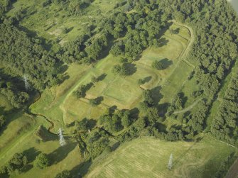 Oblique aerial view centred on the remains of the Roman fort and the course of the Antonine Wall, taken from the SW.