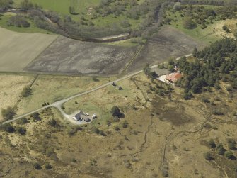 Oblique aerial view centred on the remains of the cottage, taken from the NE.