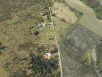 Oblique aerial view centred on the remains of the cottage, taken from the NW.