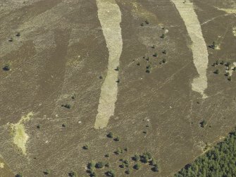 Oblique aerial view centred on the remains of the field system, rig and small cairns, taken from the W.
