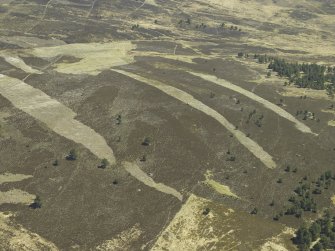 Oblique aerial view centred on the remains of the field system, rig and small cairns, taken from the W.