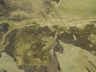 Oblique aerial view centred on the remains of the building, taken from the E