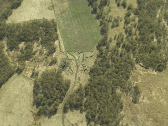 Oblique aerial view centred on the remains of the farmstead, taken from the NNE.