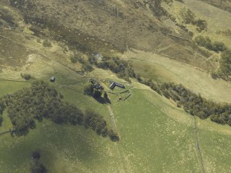 Oblique aerial view centred on the farmhouse and farmsteading with the remains of the farmstead adjacent, taken from the ENE.