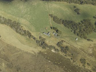 Oblique aerial view centred on the farmhouse and farmsteading, taken from the W.